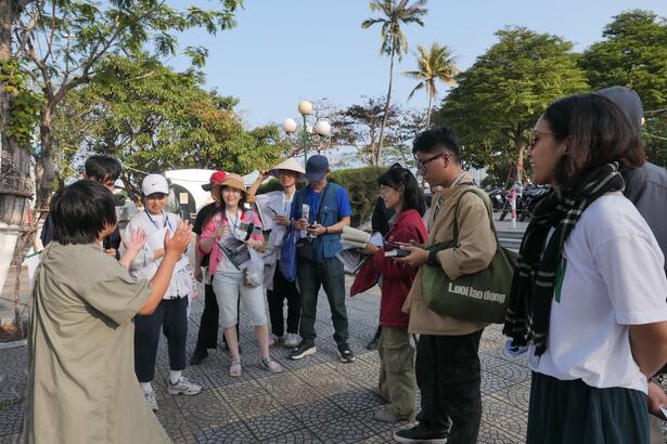 A walking tour group listening to their guide in Đà Nẵng.
