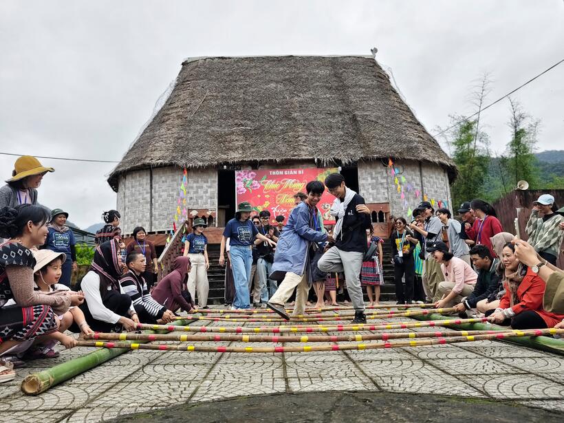 Visitors join the bamboo pole dance at the communal house of Giàn Bí village, Hòa Bắc.