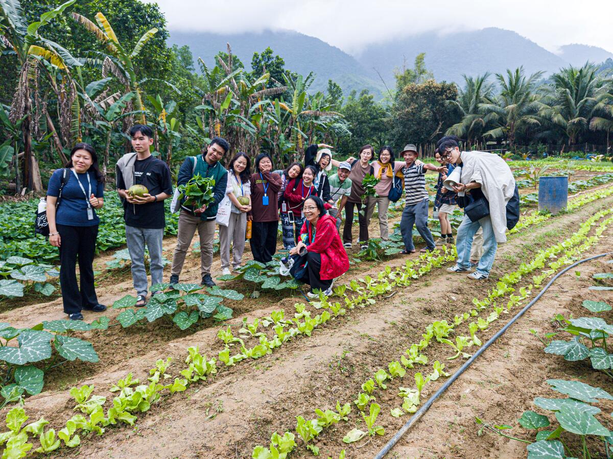 A group among the vegetable beds of an organic farm in Hòa Bắc.