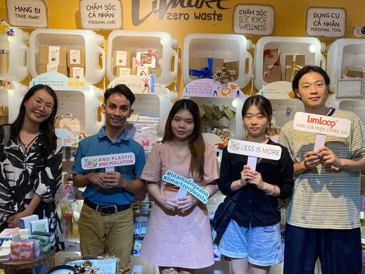 A group in a zero-waste shop in Hồ Chí Minh City, holding signs against plastic waste.