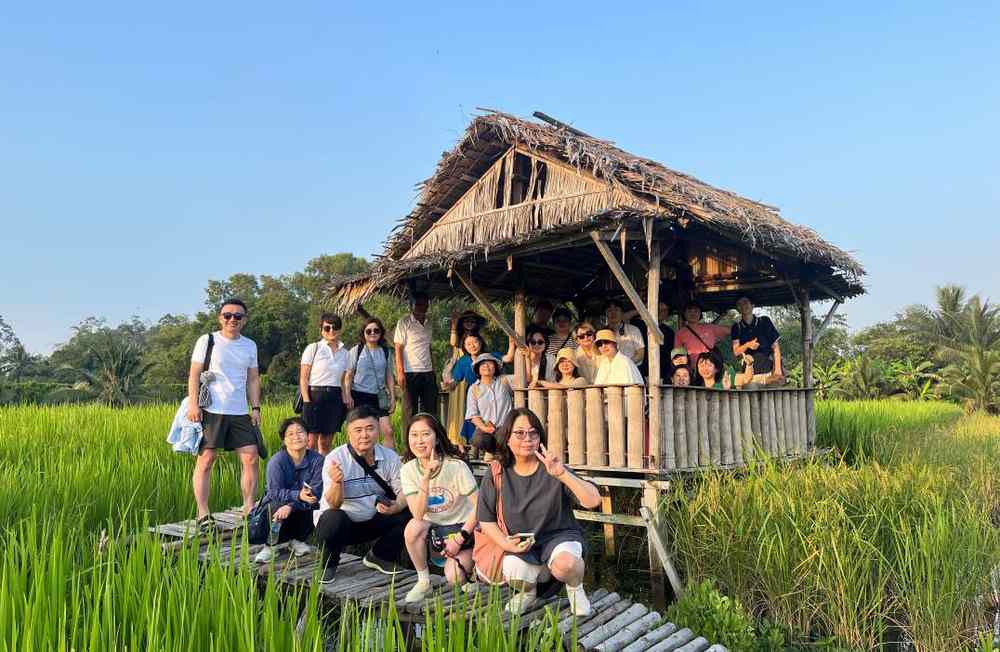 A group at a field shelter among the rice.